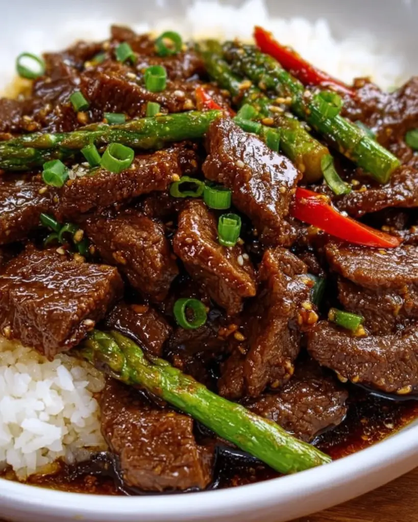 Delicious plate of Mongolian Beef with green onions and savory sauce.